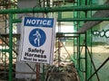 A Ã¢â¬ËSafety Harness Must be WornÃ¢â¬â¢ sign was hung as a reminder to construction workers on site. Royalty Free Stock Photo